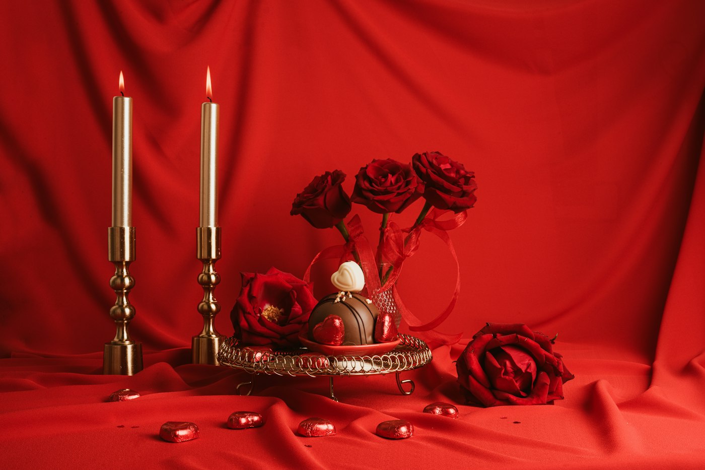 Candlelight and red roses on silk
